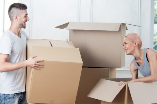 Professional movers carrying household items through a Castelnau property